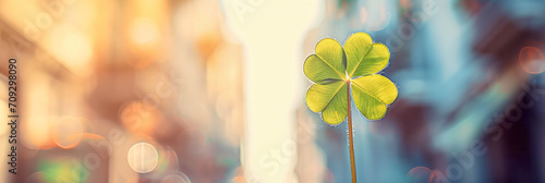 St Patrick's Day symbol and good luck charm, bright four-leaf clover against golden and sunny bokeh, background with room for text, soft focus. photo
