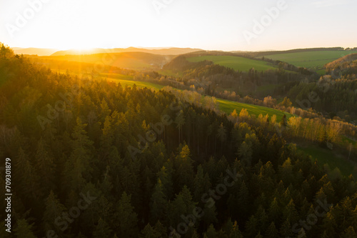 Sunset in the mountains with high trees and valleys. 