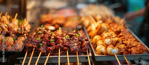 Street food carts selling barbecue with a variety of chicken and pork organs in close-up photo.