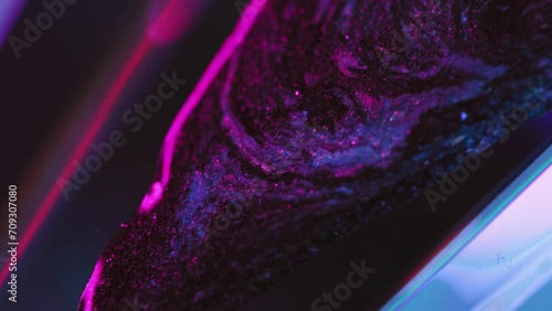 Glitter paint drip. Neon ink spill. Cyber fluid. Defocused fluorescent pink blue color glowing sparkling texture liquid flow motion abstract art background. photo