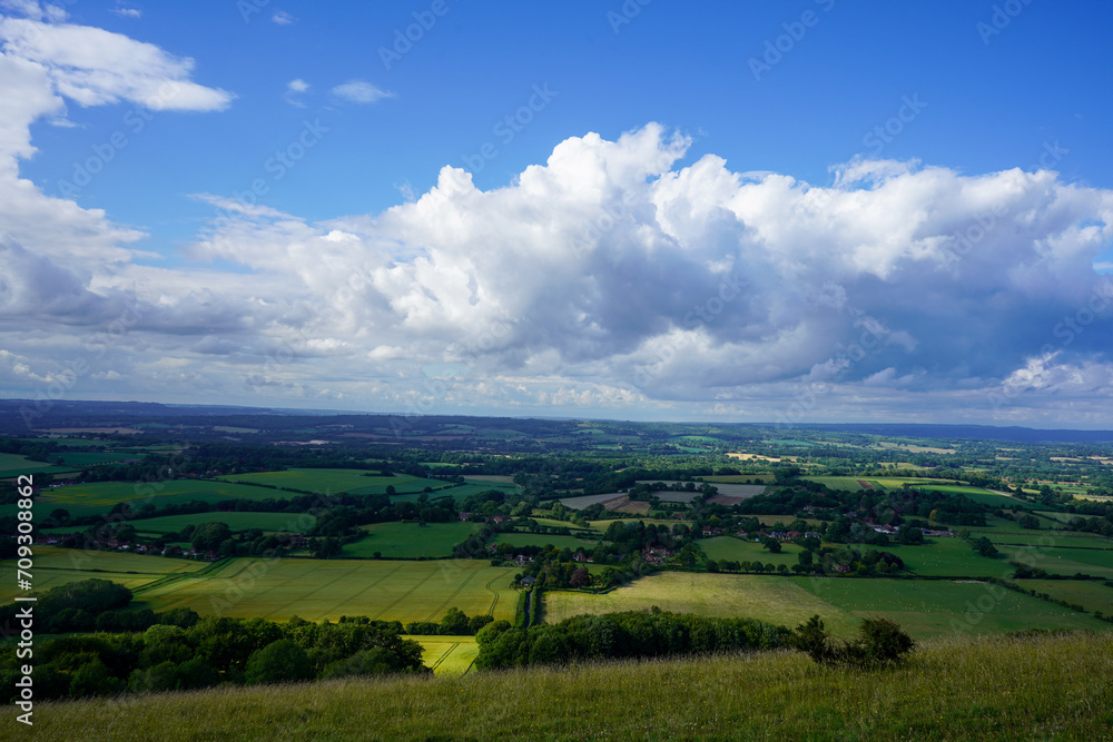 Views over countryside farm fields with clouds in blue sky in the summer
