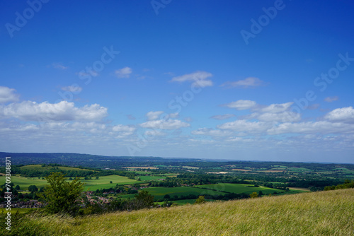 Views over countryside farm fields with clouds in blue sky in the summer