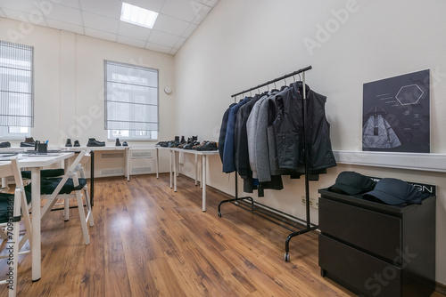 A modern showroom with clothes on a hanger, shoes on the shelves. © alhim