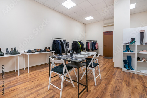 The interior of a spacious showroom with light walls and furniture for displaying clothes .and shoes. © alhim