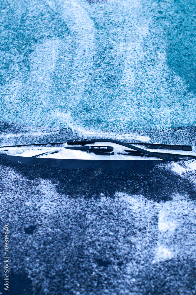 Icy windshield, wipers and hood. Winter car difficulties concept.
