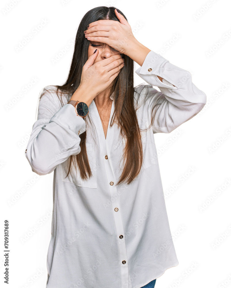Young beautiful woman wearing casual white shirt covering eyes and mouth with hands, surprised and shocked. hiding emotion Young beautiful woman wearing casual white shirt covering eyes and mouth with hands, surprised and shocked. hiding emotion