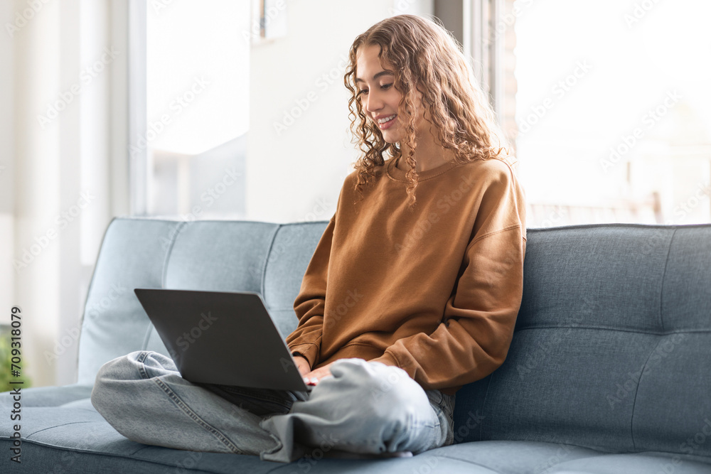 Teen student girl looking at laptop with smile browsing indoor Teen student girl looking at laptop with smile browsing indoor