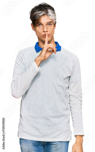 Young hispanic man wearing casual clothes asking to be quiet with finger on lips. silence and secret concept.
