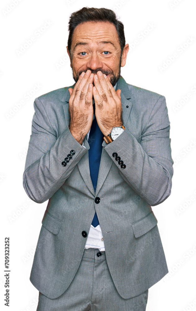 Middle age man wearing business clothes laughing and embarrassed giggle covering mouth with hands, gossip and scandal concept Middle age man wearing business clothes laughing and embarrassed giggle covering mouth with hands, gossip and scandal concept
