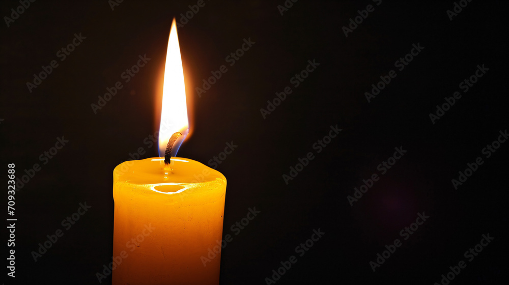 Yellow candle, light burning in the dark, candle lit in a dark environment symbolizing faith or hope Yellow candle, light burning in the dark, candle lit in a dark environment symbolizing faith or hope
