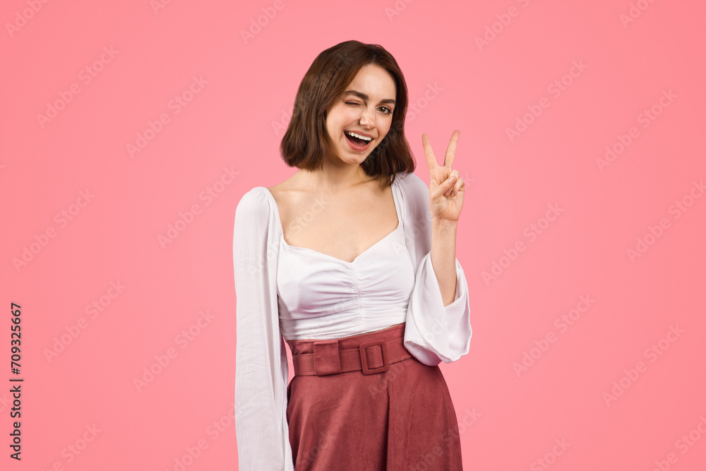 A spirited young woman winks and flashes a peace sign A spirited young woman winks and flashes a peace sign