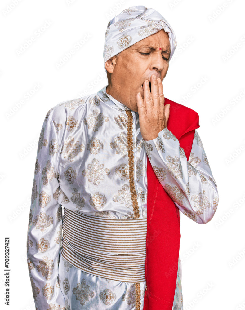 Senior hispanic man wearing tradition sherwani saree clothes bored yawning tired covering mouth with hand. restless and sleepiness. Senior hispanic man wearing tradition sherwani saree clothes bored yawning tired covering mouth with hand. restless and sleepiness.