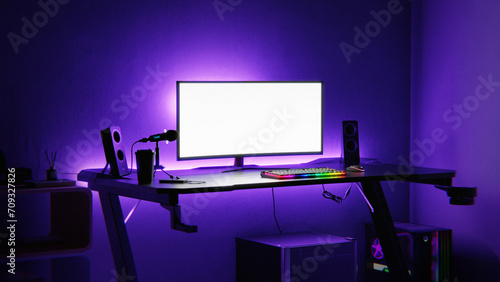 Gaming setup in a dark room with purple neon lights photo