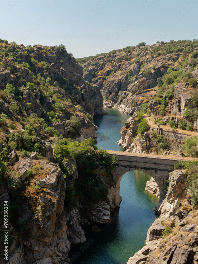 Paisaje pintoresco mediterráneo con río y puente en España.