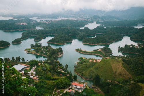 Misty lakeside landscape with lush greenery and settlements in Guatapé photo