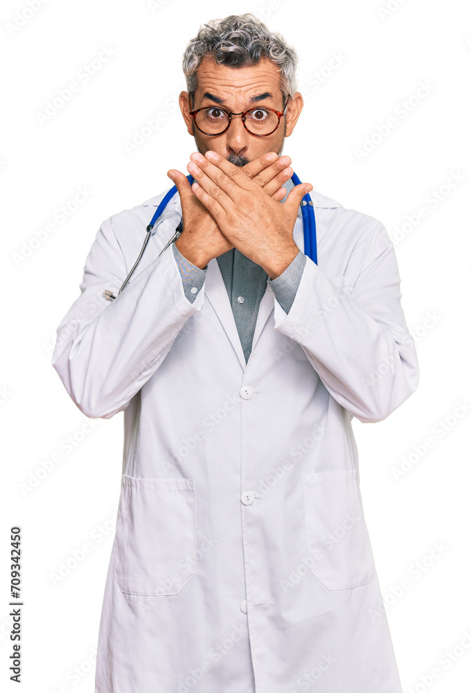 Middle age grey-haired man wearing doctor uniform and stethoscope shocked covering mouth with hands for mistake. secret concept. Middle age grey-haired man wearing doctor uniform and stethoscope shocked covering mouth with hands for mistake. secret concept.