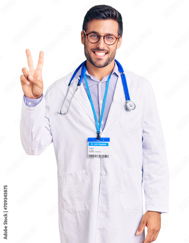 Young hispanic man wearing doctor uniform and stethoscope showing and pointing up with fingers number two while smiling confident and happy. Young hispanic man wearing doctor uniform and stethoscope showing and pointing up with fingers number two while smiling confident and happy.