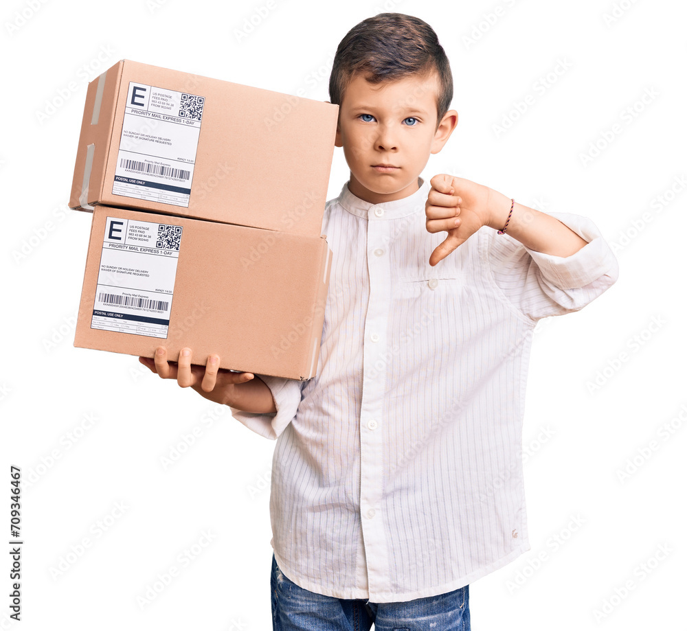 Cute blond kid holding delivery package with angry face, negative sign showing dislike with thumbs down, rejection concept Cute blond kid holding delivery package with angry face, negative sign showing dislike with thumbs down, rejection concept