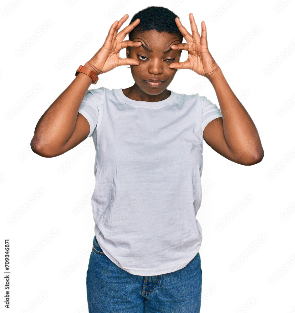 Fototapeta premium Young african american woman wearing casual white t shirt trying to open eyes with fingers, sleepy and tired for morning fatigue