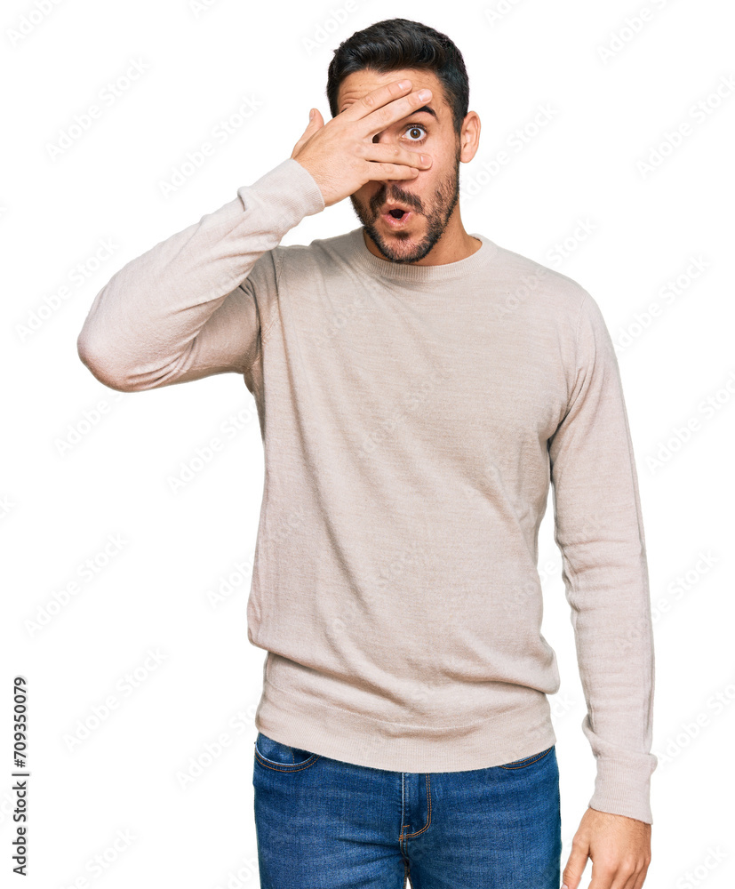 Young hispanic man wearing casual clothes peeking in shock covering face and eyes with hand, looking through fingers with embarrassed expression. Young hispanic man wearing casual clothes peeking in shock covering face and eyes with hand, looking through fingers with embarrassed expression.