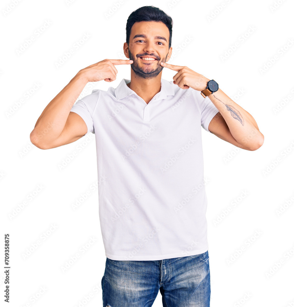 Young handsome hispanic man wearing casual clothes smiling cheerful showing and pointing with fingers teeth and mouth. dental health concept. Young handsome hispanic man wearing casual clothes smiling cheerful showing and pointing with fingers teeth and mouth. dental health concept.