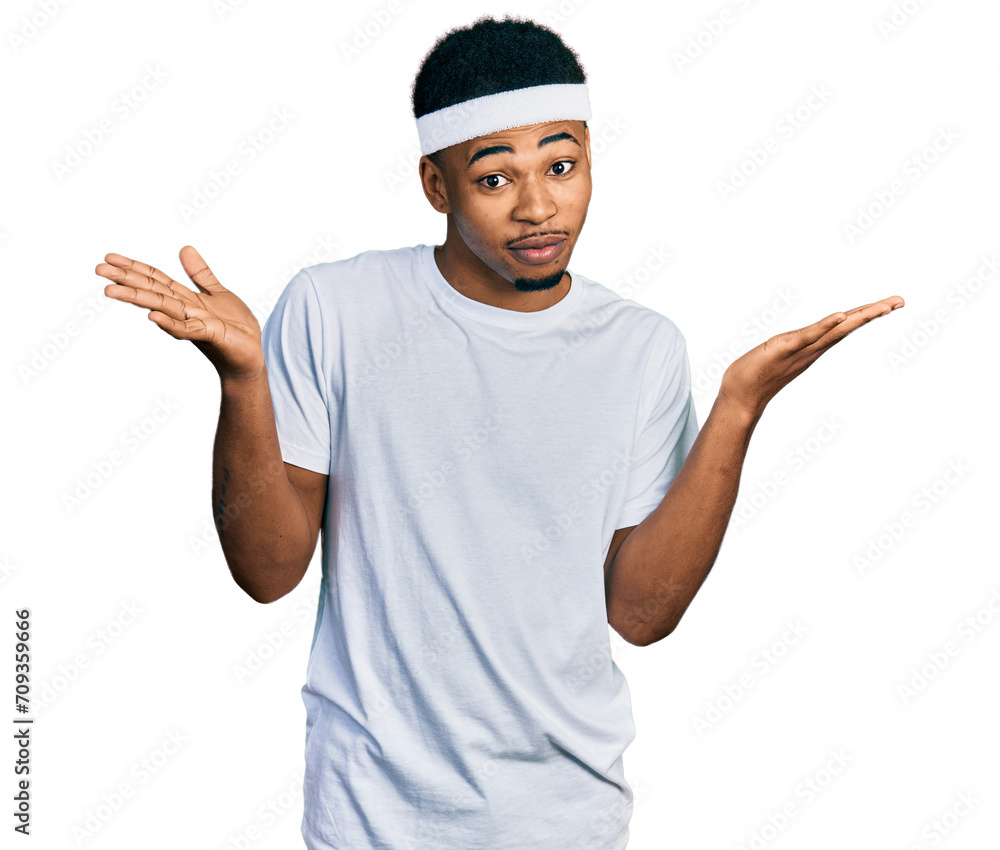 Young african american man wearing sportswear clueless and confused expression with arms and hands raised. doubt concept. Young african american man wearing sportswear clueless and confused expression with arms and hands raised. doubt concept.