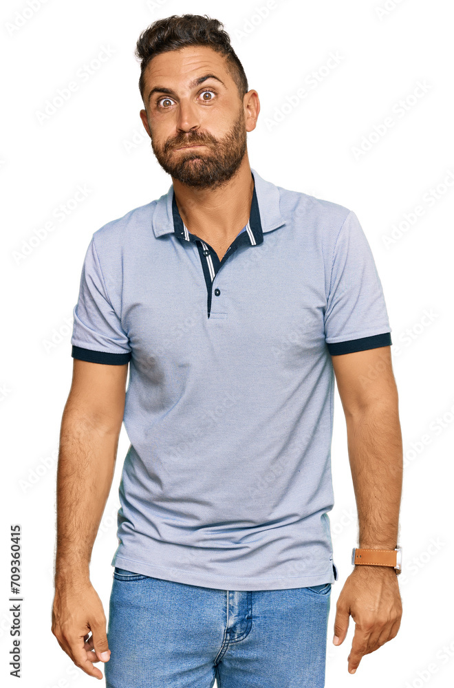 Handsome man with beard wearing casual clothes puffing cheeks with funny face. mouth inflated with air, crazy expression. Handsome man with beard wearing casual clothes puffing cheeks with funny face. mouth inflated with air, crazy expression.