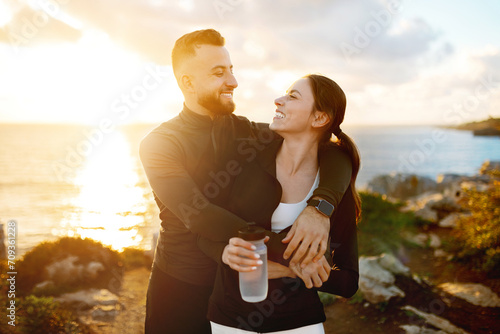 Affectionate couple embracing during sunset coastal walk © Prostock-studio