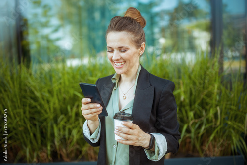 happy business woman near business center using smartphone
