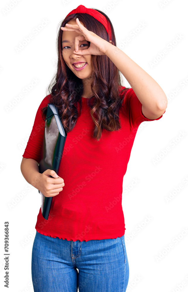 Young beautiful chinese girl wearing student folder smiling happy doing ok sign with hand on eye looking through fingers Young beautiful chinese girl wearing student folder smiling happy doing ok sign with hand on eye looking through fingers
