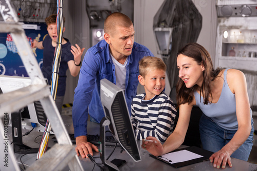 Portrait of a friendly family at a computer, thinking about solving a puzzle in a quest room, stylized as a laboratory