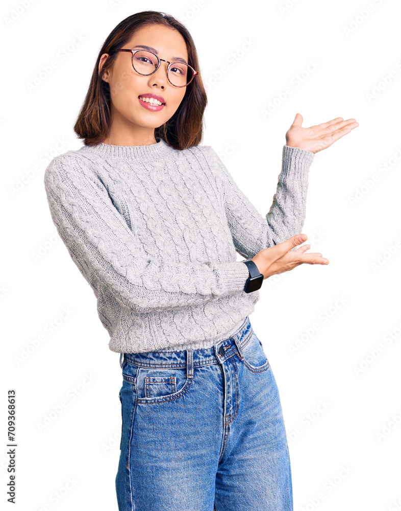 Young beautiful chinese girl wearing casual clothes inviting to enter smiling natural with open hand Young beautiful chinese girl wearing casual clothes inviting to enter smiling natural with open hand