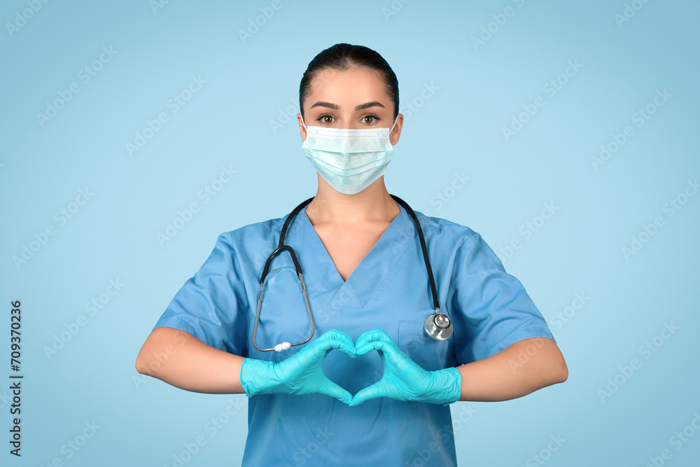 Caring nurse with heart hands, blue scrubs Caring nurse with heart hands, blue scrubs