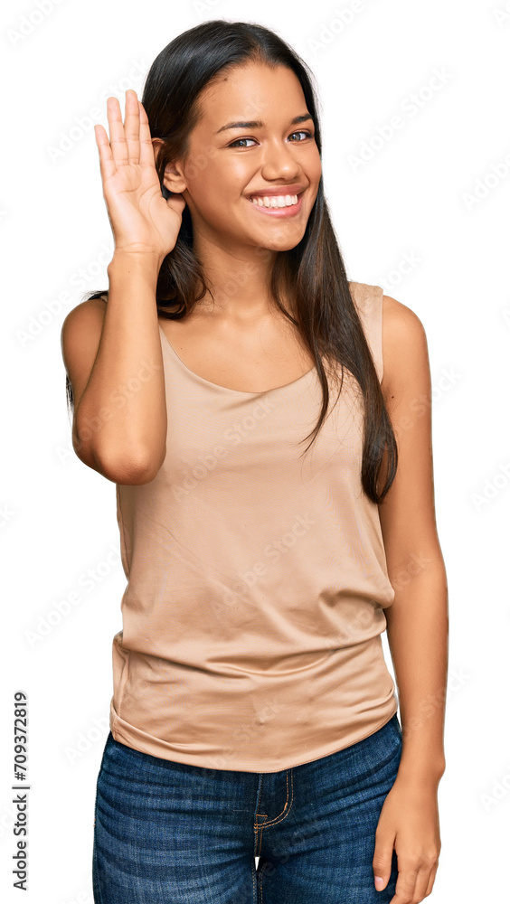 Beautiful hispanic woman wearing casual clothes smiling with hand over ear listening an hearing to rumor or gossip. deafness concept. Beautiful hispanic woman wearing casual clothes smiling with hand over ear listening an hearing to rumor or gossip. deafness concept.
