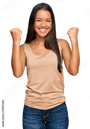 Beautiful hispanic woman wearing casual clothes celebrating surprised and amazed for success with arms raised and open eyes. winner concept.