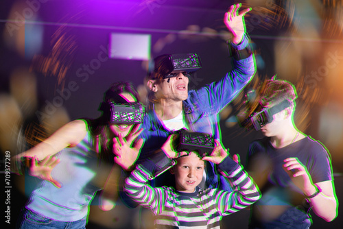 Positive family with children playfully poses in virtual reality glasses