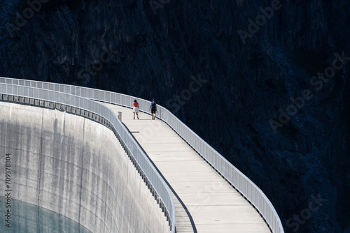 Touristen auf Staumauer am Lünersee im Montafon