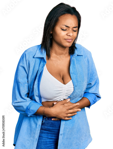 Beautiful hispanic woman wearing casual denim jacket with hand on stomach because indigestion, painful illness feeling unwell. ache concept. © Krakenimages.com