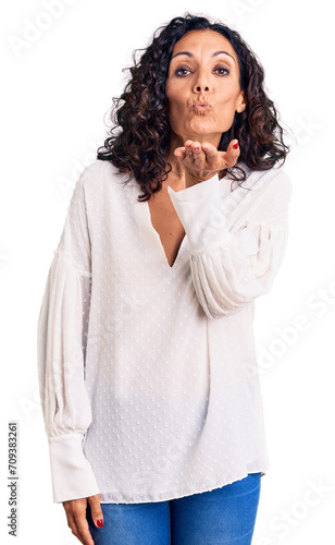 Middle age beautiful woman wearing casual sweater looking at the camera blowing a kiss with hand on air being lovely and sexy. love expression.