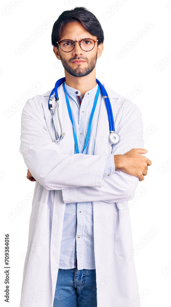 Handsome hispanic man wearing doctor uniform and stethoscope skeptic and nervous, disapproving expression on face with crossed arms. negative person. Handsome hispanic man wearing doctor uniform and stethoscope skeptic and nervous, disapproving expression on face with crossed arms. negative person.