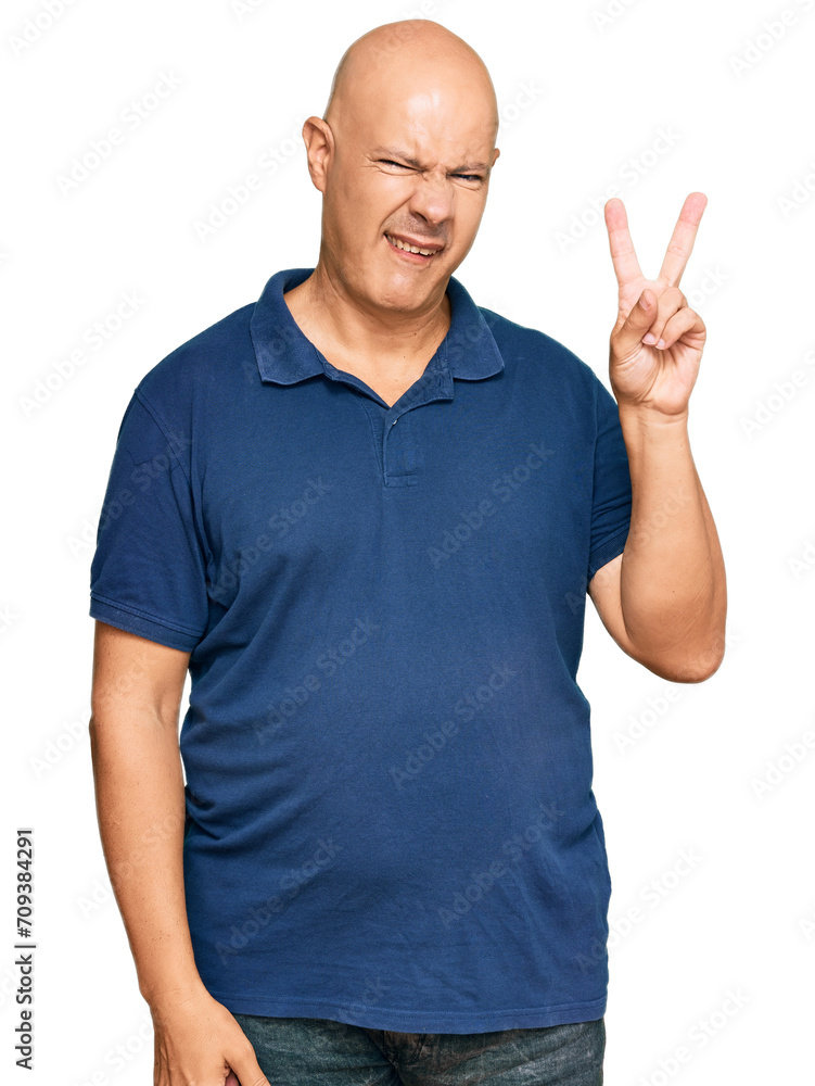 Middle age bald man wearing casual clothes smiling with happy face winking at the camera doing victory sign. number two. Middle age bald man wearing casual clothes smiling with happy face winking at the camera doing victory sign. number two.