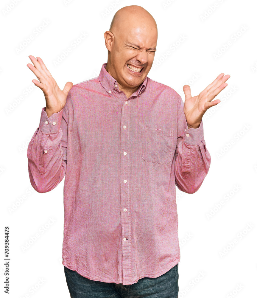 Middle age bald man wearing casual clothes celebrating mad and crazy for success with arms raised and closed eyes screaming excited. winner concept Middle age bald man wearing casual clothes celebrating mad and crazy for success with arms raised and closed eyes screaming excited. winner concept