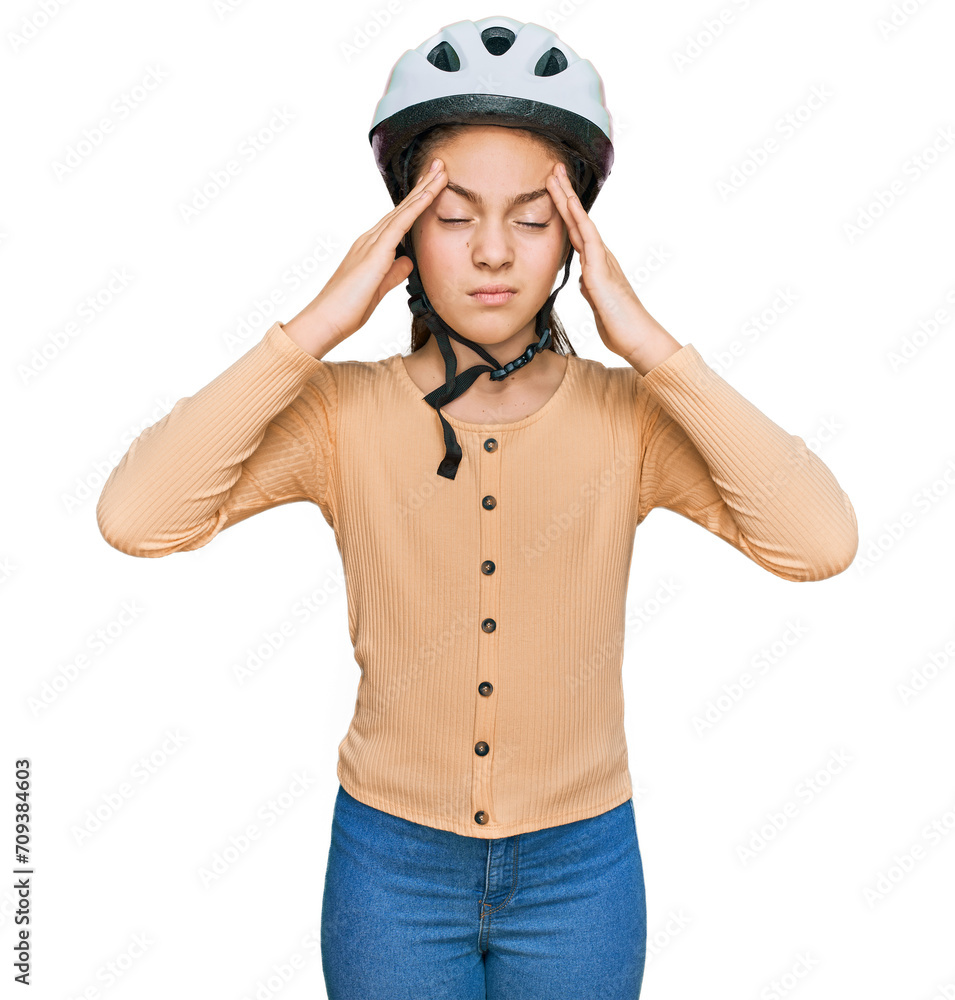 Beautiful brunette little girl wearing bike helmet suffering from headache desperate and stressed because pain and migraine. hands on head. Beautiful brunette little girl wearing bike helmet suffering from headache desperate and stressed because pain and migraine. hands on head.