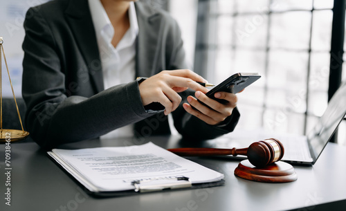 justice and law concept. Male judge in a courtroom the gavel, working with smart phone and laptop and digital tablet computer on desk