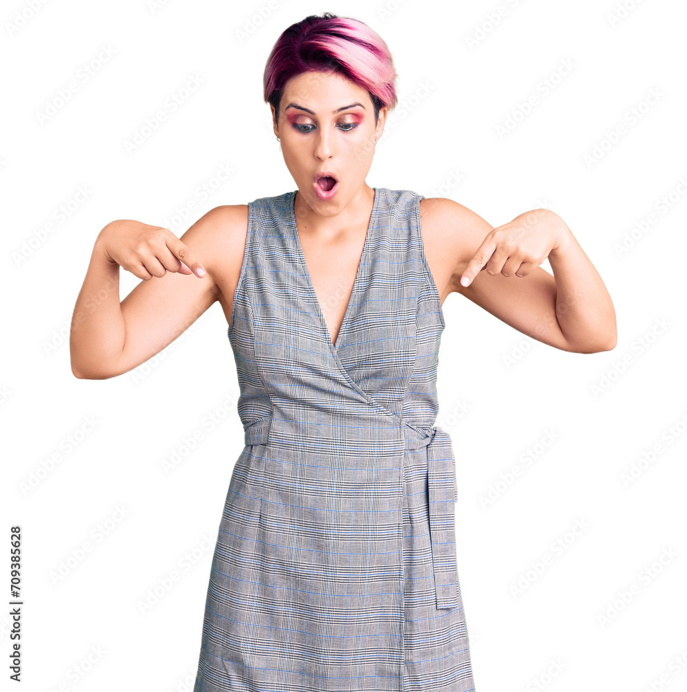 Young beautiful woman with pink hair wearing casual clothes pointing down with fingers showing advertisement, surprised face and open mouth Young beautiful woman with pink hair wearing casual clothes pointing down with fingers showing advertisement, surprised face and open mouth