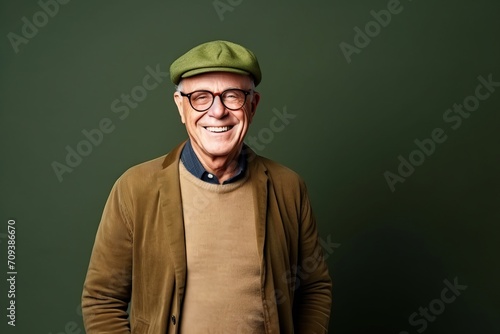 Portrait of a smiling senior man wearing a beret and glasses. © Igor