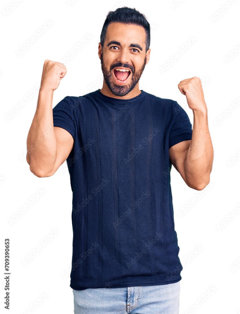 Young hispanic man wearing casual clothes screaming proud, celebrating victory and success very excited with raised arms Young hispanic man wearing casual clothes screaming proud, celebrating victory and success very excited with raised arms