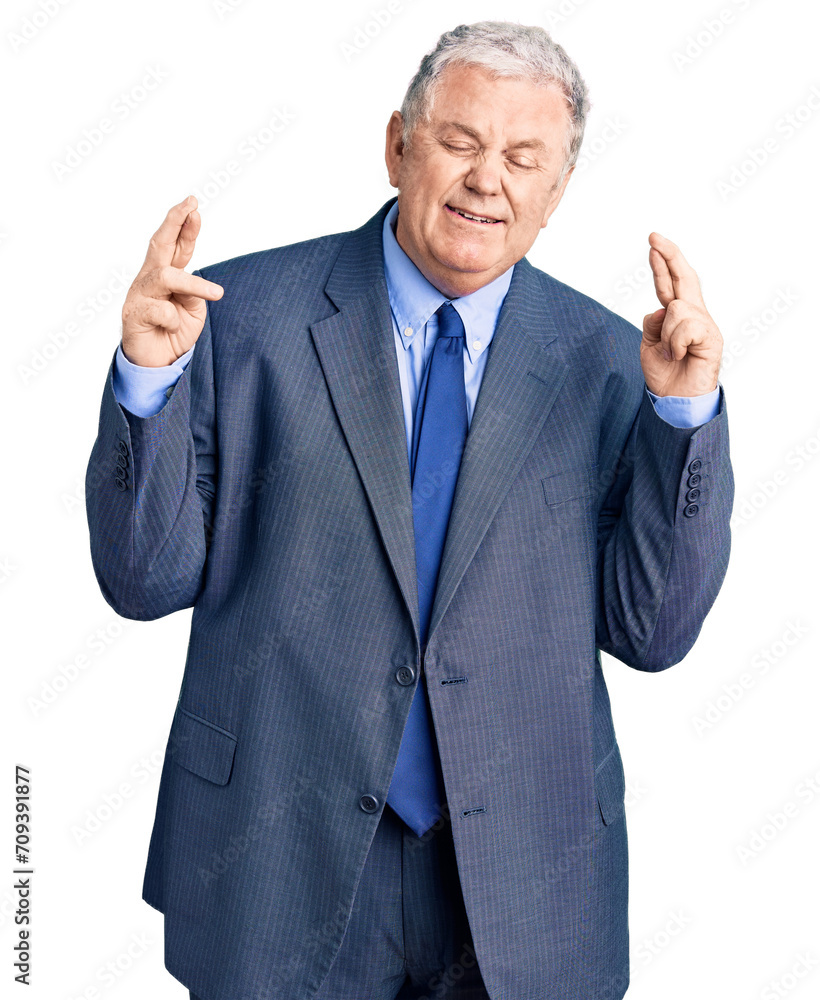 Senior grey-haired man wearing business jacket gesturing finger crossed smiling with hope and eyes closed. luck and superstitious concept. Senior grey-haired man wearing business jacket gesturing finger crossed smiling with hope and eyes closed. luck and superstitious concept.