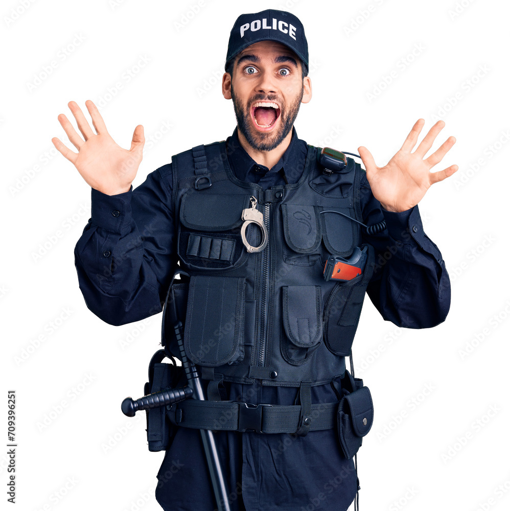 Young handsome man with beard wearing police uniform celebrating crazy and amazed for success with arms raised and open eyes screaming excited. winner concept Young handsome man with beard wearing police uniform celebrating crazy and amazed for success with arms raised and open eyes screaming excited. winner concept