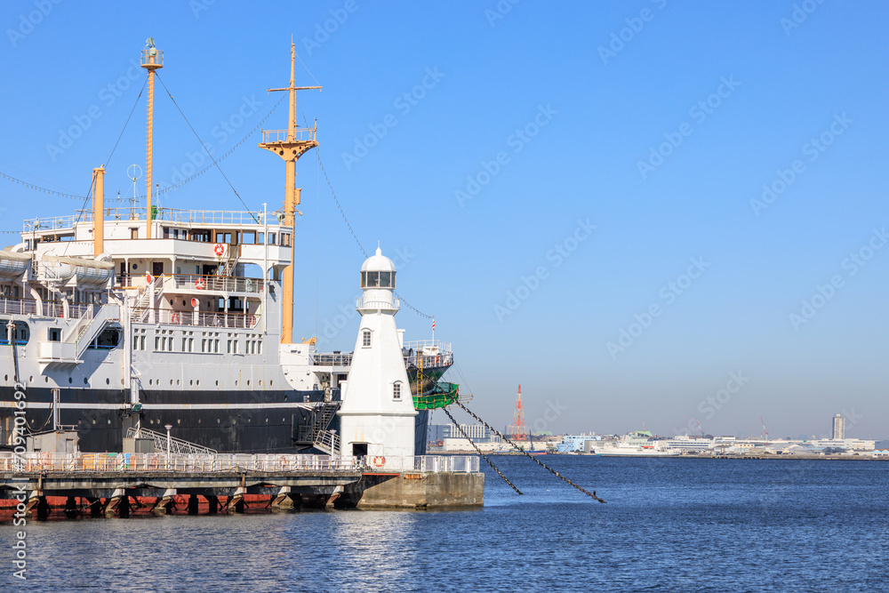 桟橋に係留されている客船と白い灯台